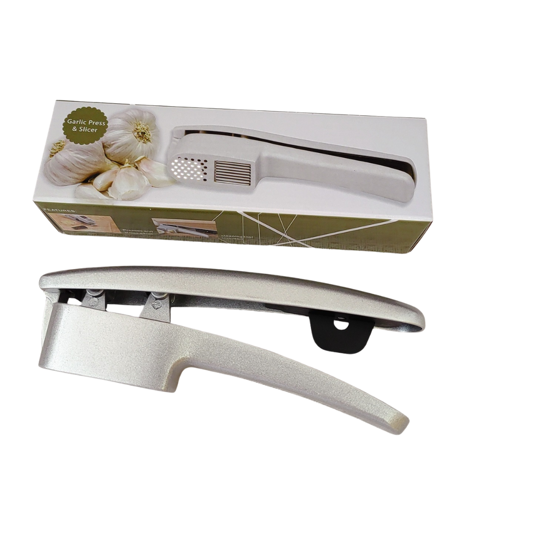 Knoblauchpresse in Silber liegt neben der Produktverpackung.