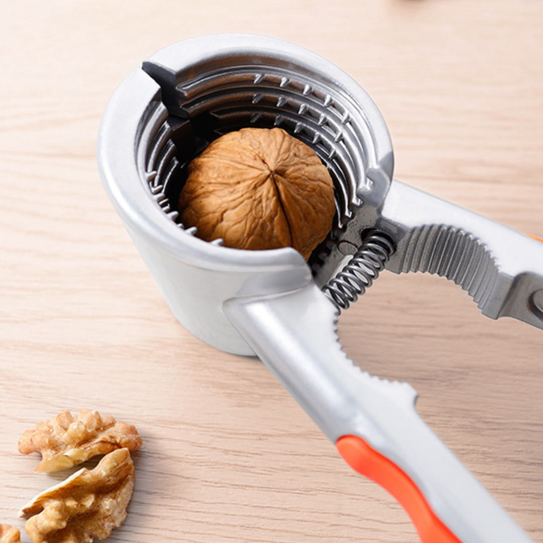 Nussknacker in Silber mir orangen Griffen (Nahaufnahme). Im Nussknacker befindet sich eine Walnuss.